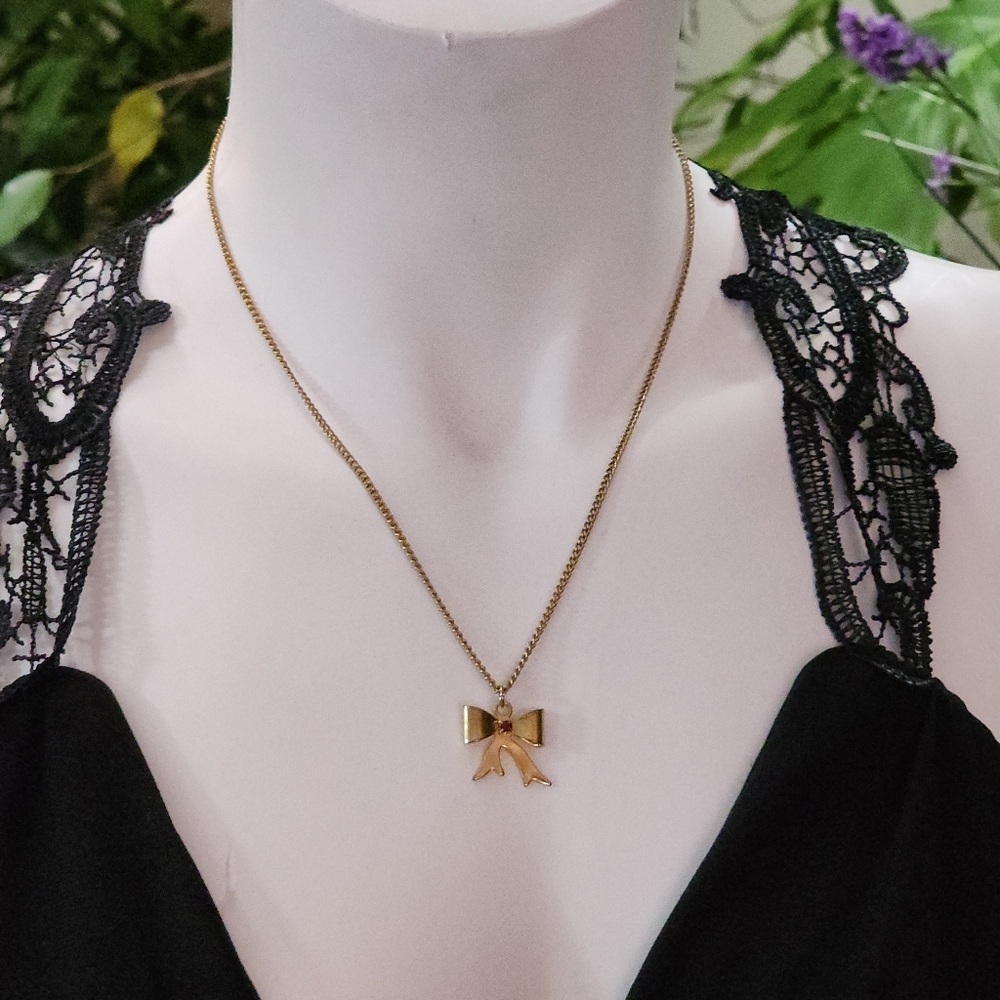 Chic Gold Toned Bow Pendant Necklace With Red Gemstone